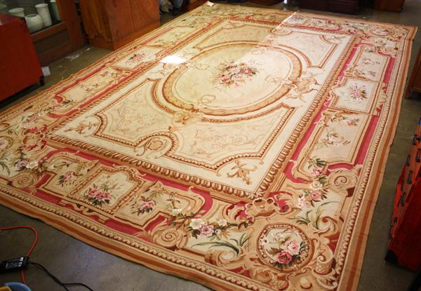 Aubosson style flat weave rug: Aubusson style flat weave rug, having a tan field with a floral spray between the wreath form medallion, the border will scrolling reserves, 13'9'' x 9'5''
