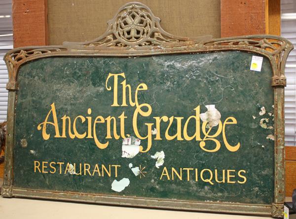 Art Nouveau business sign: Art Nouveau business sign having a wrought iron frame holding a painted metal panel for ''The Ancient Grudge Restaurant Antiques'', 27''h x 38''w, some paint loss