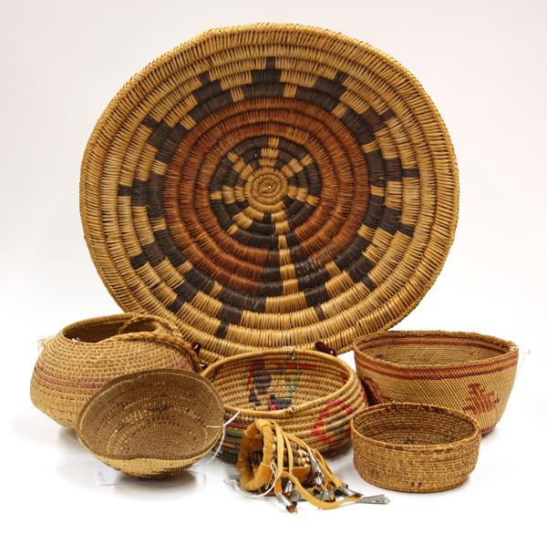Group of Native American baskets: (lot of 7) Group of woven baskets including: an Apache Child's burden basket, a Navajo wedding tray, a Nootka Makah basket, a Hupa basket lid and two Mexican baskets, etc., largest 3''h x 16''w