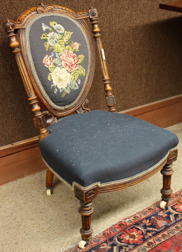 Victorian Slipper Chair: Victorian slipper chair circa 1870, executed in the French taste, having an arched crestrail above the shield back covered in floral needlepoint, flanked by the fluted stiles and rising on turned legs