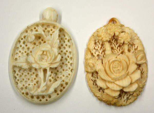 Pierced Chinese Ivory Floral Pendants: (lot of 2) Chinese carved ivory pendants, each of flatten ovoid form, the first of a rosette sprig on a star-pierced ground, 2.25''h; the second featuring a large rosette below a daisy, 2''h