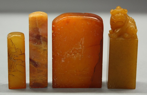 Chinese Yellow Soapstone Seals: (lot of 4) Chinese soapstone seals: the first carved with a fu-lion on tall plinth, base uncarved, all of light honey hue mottled by occasional flecks, 3.1''h; second with a rounded top with the shaft