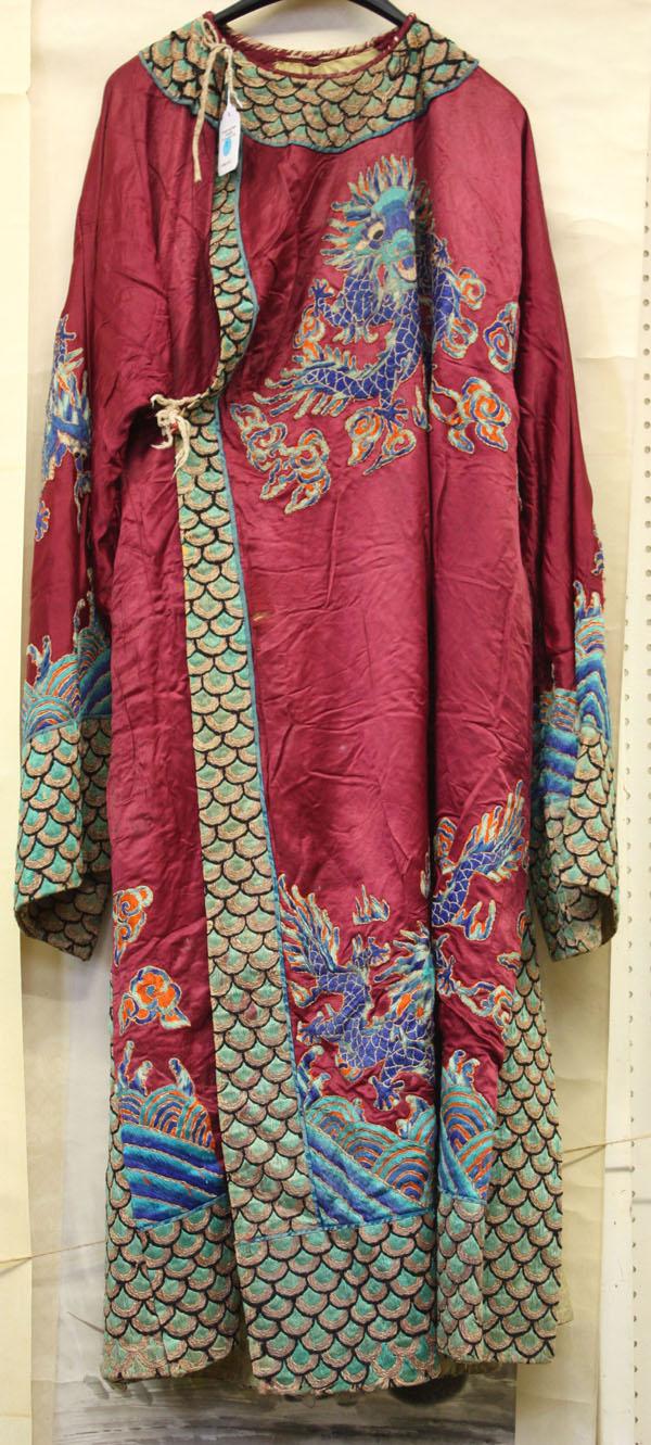Chinese Embroidered Theatrical Robe/Costume: Chinese embroidered silk theatrical robe, decorated with eight blue dragons amid a magenta colored silk ground, accented by a embroidered and couched scale pattern to the collar, hem and sleeve, rever