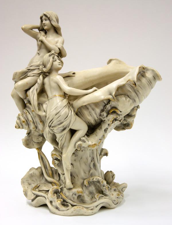 Royal Dux porcelain figural group: Royal Dux, Bohemian porcelain figural group, depicting maidens alighting on a seashell, rising on a naturalistic base with flowering lilly pads, 16.5''h x 14''w