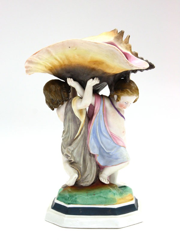 Porcelain figural group: Bisque porcelain figural group, depicting two classical children carrying a seashell spill, rising on a naturalistic partial glazed plinth, unsigned 10.5''h x 5''w