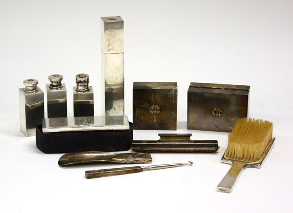 Tiffany & Co. sterling gentleman's dresser set: Tiffany & Co. sterling silver twelve piece gentleman's dresser set including clothes and hair brush, talc shaker, cologne bottles, boxes, file, button hook, nail buffer, and shoe horn, monogramed in g