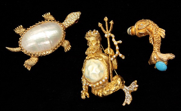 Fashion jewelry, Hattie Carnegie pins: (lot of 3) Hattie Carnegie fashion jewelry pins including; a gold tone turtle with mother of pearl shell, ruby red rhinestone eyes and clear rhinestone accents, a gold tone ''Neptune'' pin centered by