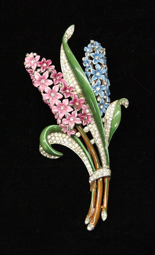 Trifari fashion jewelry fur clip: Trifari fur clip with blue and pink enameled lilac flowers centered with clear rhinestones and flanked with green enamel and clear rhinestone leaves, 53mm x 110mm