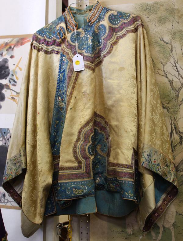 Chinese Woman's Silk Robes: (lot of 2) Chinese woman's informal short silk robes, the first of a golden hue satin with damask pattern of cranes, clouds, and Buddhist emblems, accented by a blue border with satin stitched figural
