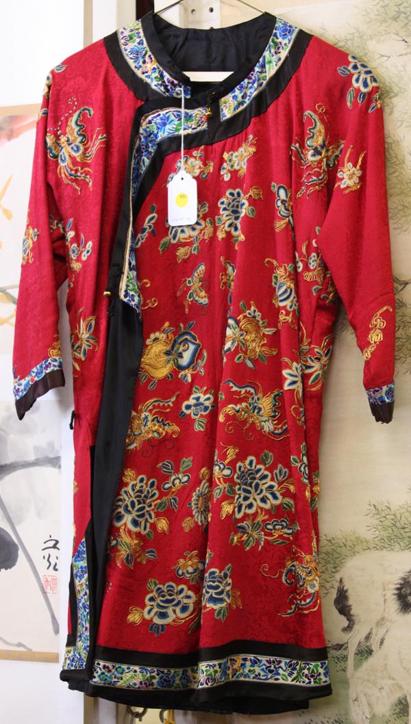 Chinese Woman's Informal Robe: Chinese Han woman's informal red silk robe, featuring bright butterflies, peaches, gourds, peonies and various floral sprigs picked out in Peking knots, satin stitches, and gilt couching on a damask g