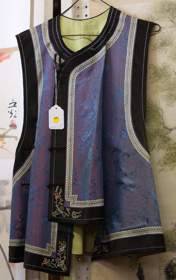 Chinese Informal Vest and Robe: (lot of 2) Chinese woman's vest and robe, the first a lavender grounded informal vest woven with the eight Daoist treasures amid cloud scrolls in blue, with lime-green lining, 28''h; second a dark pur