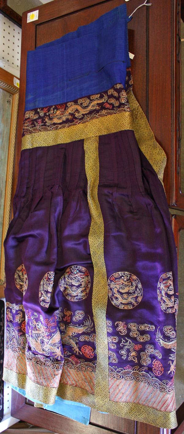 Chinese Chaofu-style Skirt: Chinese Manchu formal chaofu-style purple silk skirt, composed of two overlapping panels with one featuring eight dragon roundels couched in metallic wrapped threads above a pair of confronting dragon