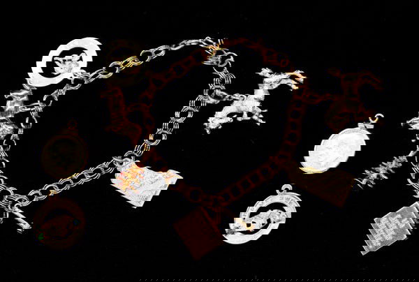 Yellow gold charm bracelet: 14k yellow gold charm bracelet; with (4) 14k yellow gold charms, (3) fashion charms and (1) 2 1/2 Pesos coin charm. Total bracelet and charms weight 27.4 grams