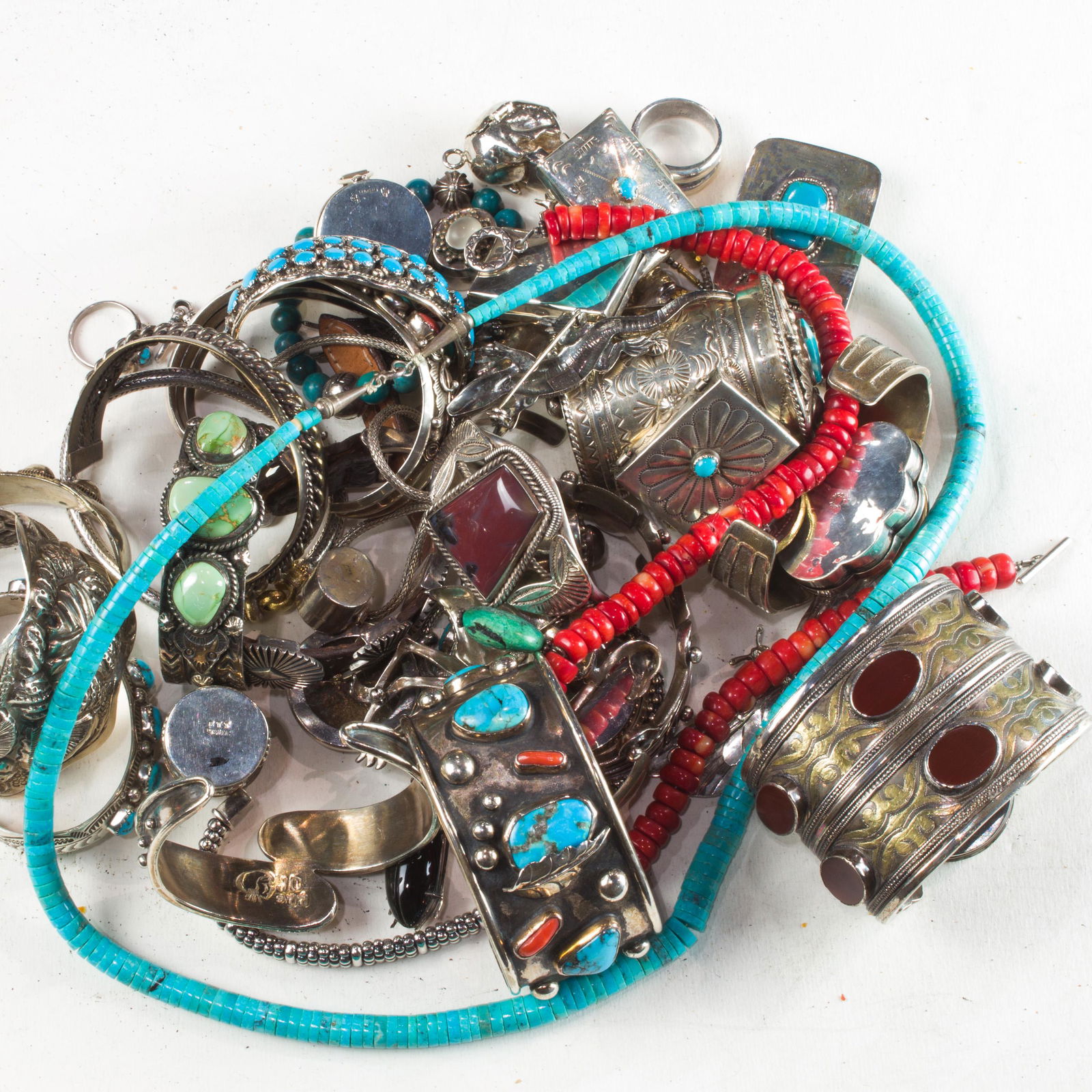 A group of silver jewelry: A group of silver jewelryincluding fourteen silver bangle bracelets set with turquoise or coral; two silver link bracelets; a turquoise bead bracelets; a silver and leather bracelet; two silver rings;