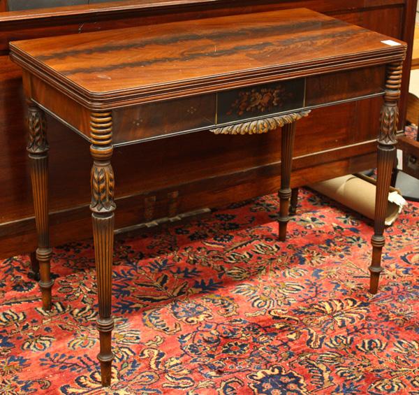 American mahogany federal style card table: American mahogany federal style card table, with an oblong top of flame mahogany, above a polychrome decorated conforming apron, rising on ring turned and reeded tapering legs, terminating in peg feet