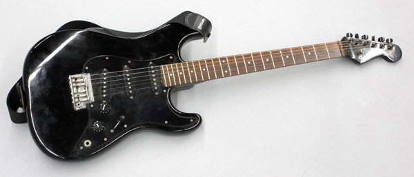 Fender Stratocaster electric guitar: Fender Stratocater electric guitar serial number A003608, having a black body and pick guard, with a rosewood fretboard, made in Japan