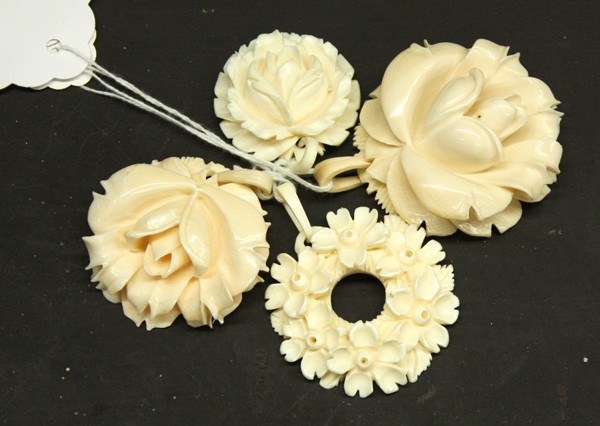 Ivory Floral Pendents: (lot of 4) Carved ivory pendants, consisting of three each delicately fashioned as blossoming rosettes, largest: 2.25''h and one shaped as a wreath formed by five-petal flowers, 2''dia