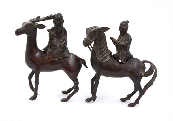 Chinese Bronze Immortals and Mounts: (lot of 2) Chinese patinated bronze sages on mounts, each figure separately cast with a scroll held in his hand, the first riding a mule while the other is supported by a deer (minor losses), largest: