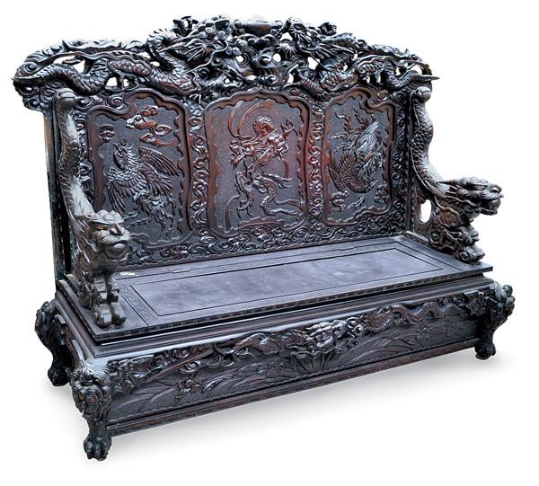 Japanese Export Settee, Draong: Japanese massive ebonized wood export settee, the top rail elaborately carved and pierced with a pair of large writhing dragons contesting a sacred jewel and looming above three sunken reserves of a f