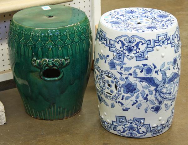 Chinese Porcelain Garden Seats: (lot of 2) Chinese barrel-form porcelain garden seats, the first covered in a dark green glaze and molded with a band of flowers suspending a garland above the handles accented with stylized bats; the