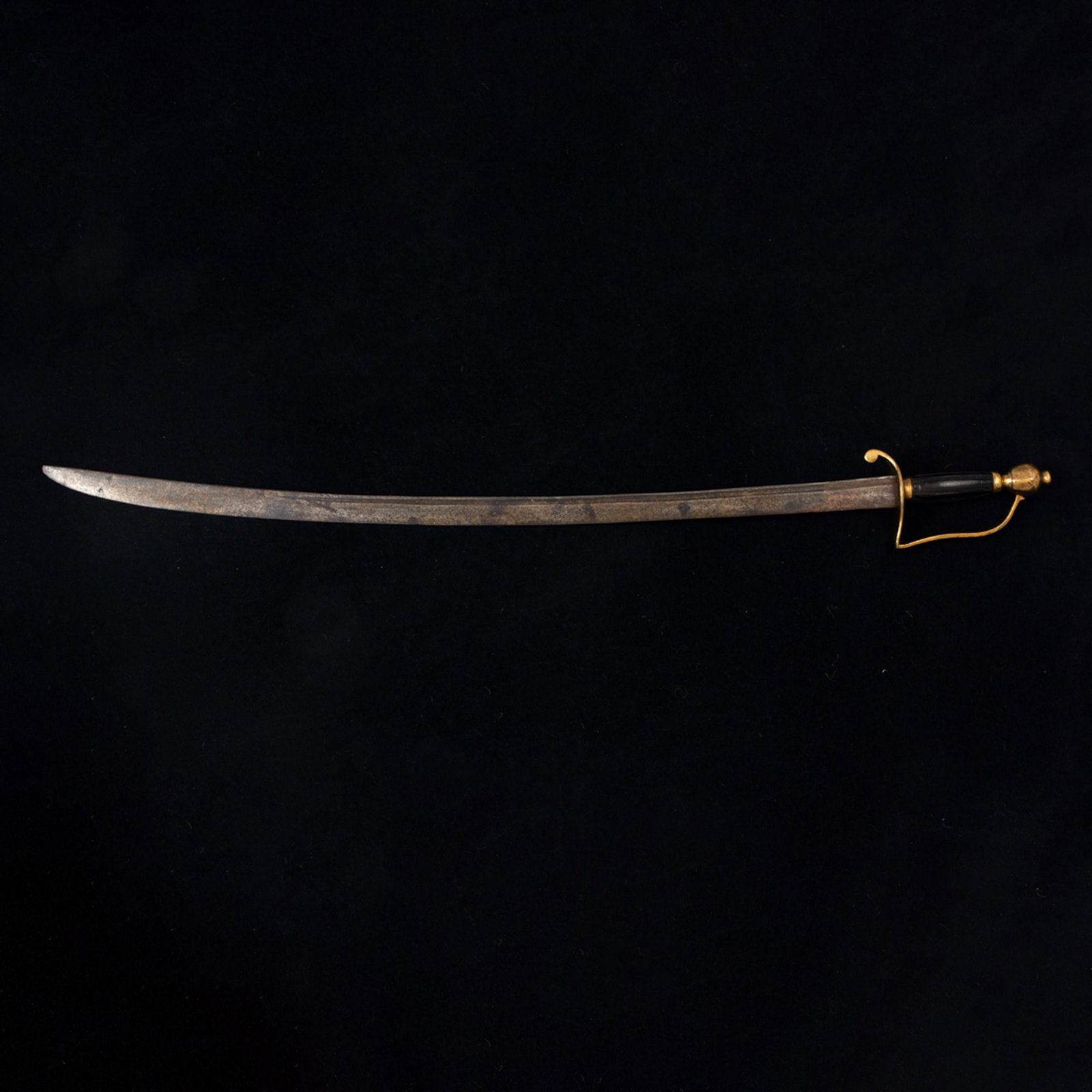 An American sabre, 19th century, a copper alloy round: An American sabre, 19th century, a copper alloy round pommel hilt, a "D" form guard, an ebonized and grooved wood hilt, hand forged blade with a fuller, 35.25"l (lacking scabbard)