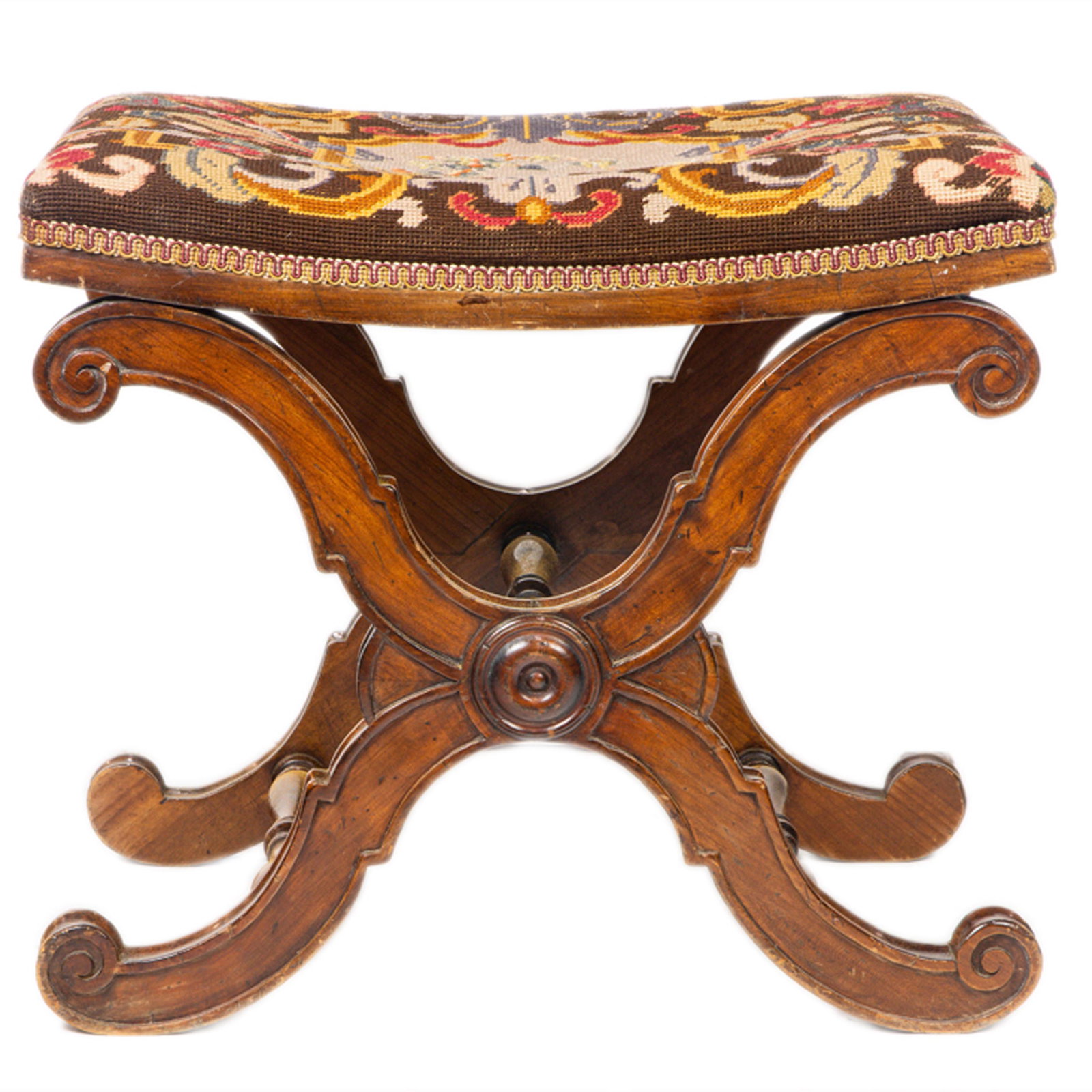 A continental Renaissance style ottoman: A continental Renaissance style ottoman, executed in walnut, having X form supports with turned stretchers supporting the needlepoint seat, 13"h x 21"w x 16"d