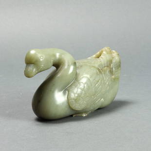 Chinese celadon jade goose: Chinese celadon jade goose, carved in the round with the head of the goose looking forward, the wing and tail feathers incised in details, the webbed feet tucked underneath carved in shallow relief, 5