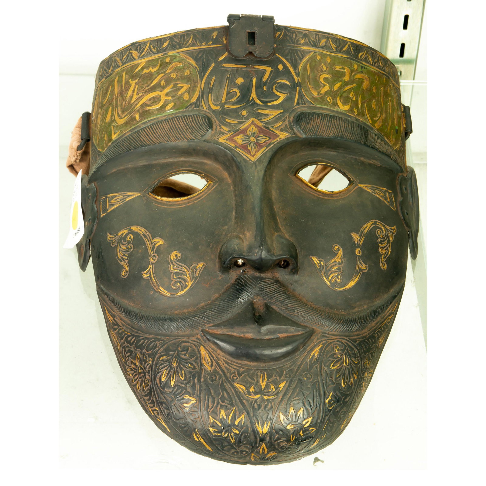 Modern Mask of Thin Metal, Indonesian Style: Modern Mask of Thin Metal, Indonesian Style, with design on forehead in gold color, cloth attached, late 20th century and not a traditional style, 10"h