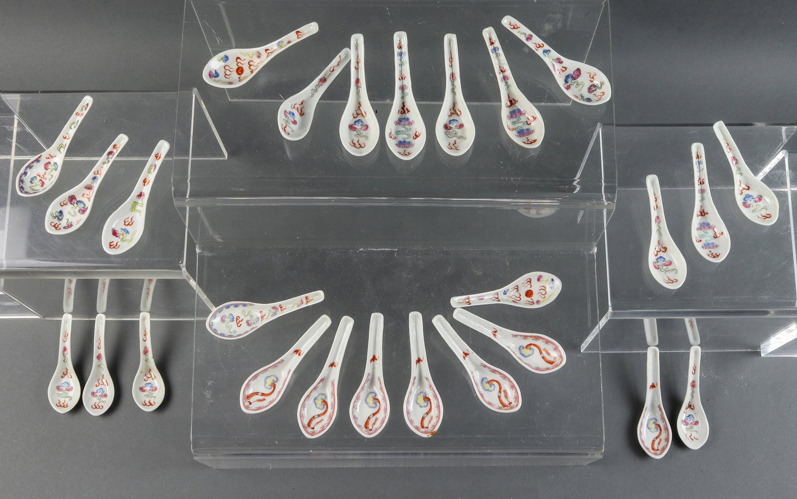 (lot of 26) Chinese famille rose spoons: (lot of 26) Chinese famille rose spoons, comprising nineteen spoons depicting scrolling clouds and flames, and seven with a ruyi scepter and a bat, each approx. 3.5"l.