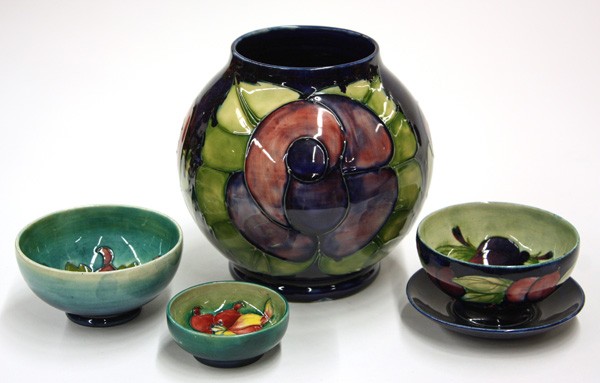 Moorcroft pottery vase and three bowls: (Lot of 4) Moorcroft pottery vase and three bowls, William Moorcraft 'WM' initials on base of the vase, and three small bowls decorated with persimmons, largest 7''h x 7''w