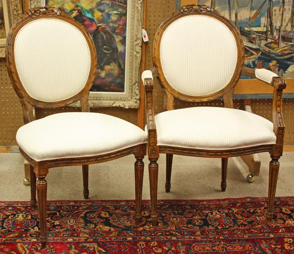 Louis XVI style chairs: (lot of 2) Louis XVI style chairs, having a carved crest rail above the circular padded back, the arm chair with carved returns terminating at the rosette medallions and rising on turned fluted legs, 