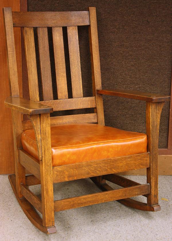 Charles Stickley tall back arm rocker: Charles Stickley tall back arm rocker, having four vertical slats terminating at the double steam bent horozontal slats, the wide arms supported with long corbels, signed with stamp on rear stretcher,