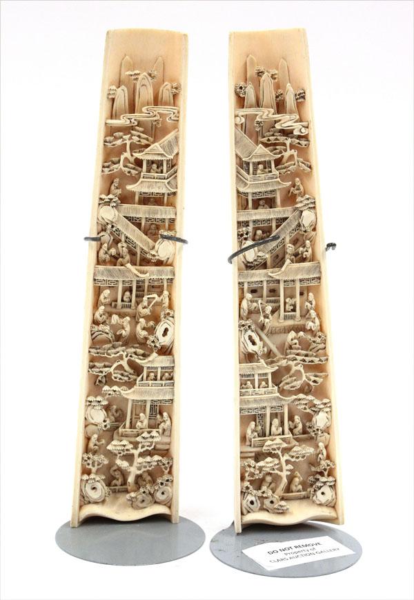 Pair Chinese Ivory Wrist Rests, Qing Dynasty: Pair of Chinese ivory wrist rests, Qing dynasty, the interior or each curved section of tusk carved and undercut with an imaginary landscape with miniature figures traversing terraces and walkways lea