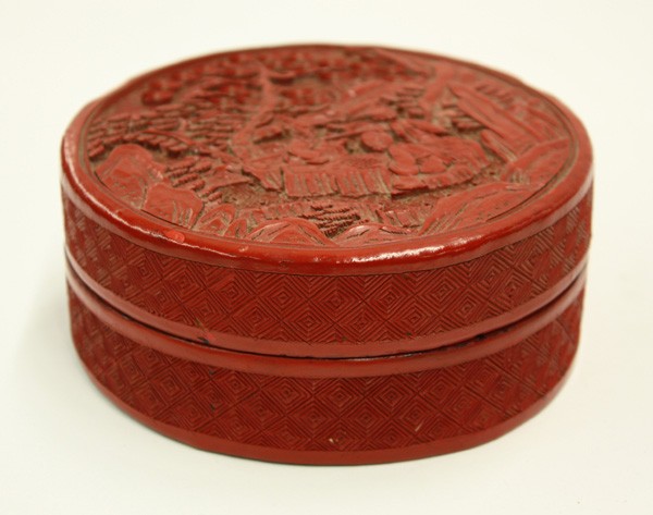 Chinese Cinnabar Lacquer Circular Box: Chinese cinnabar lacquer circular box, early 20th century, the fitted cover carved and incised with a maiden watching a pair of sages playing wei qi on a garden terrrace, marked 'China' on the base (s