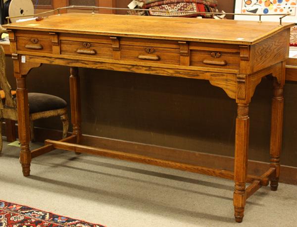 Victorian oak drafting table: Victorian oak drafting table circa 1890, executed in the Modern Gothic style, the galleried top over a four drawer case rising on block and turned legs conjoined by a stacked H-stretcher, 48''h x 73''