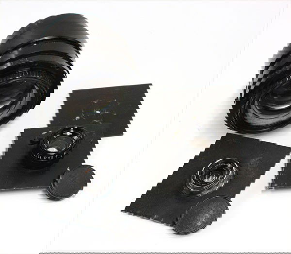 Nikon & Schneider darkroom lenses: (lot of 4) Nikon 50mm f2.8 and a Schneider Componon 80mm f5.6 darkroom enlarger lenses, with two lenses mounted to a 4''x4'' lens board, one extra lens board with a 0.25'' hole, and a German f5.6 tele