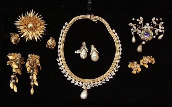 Fashion jewelry including Hattie Carnegie: (lot of 7) pieces of fashion jewelry including; a Hattie Carnegie gold tone sunburst brooch and earrings; Carnegie gold tone dangle clip on earrings with leaf form and faux pearl drops; a pair of Carn
