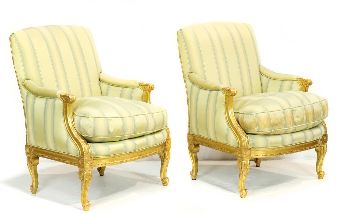 A pair of giltwood carved bergeres: A pair of giltwood carved bergeres, each having a drop in down seat with acanthus carved returns, and rising on carved cabriole legs, 37"h x 26"w x 22"d