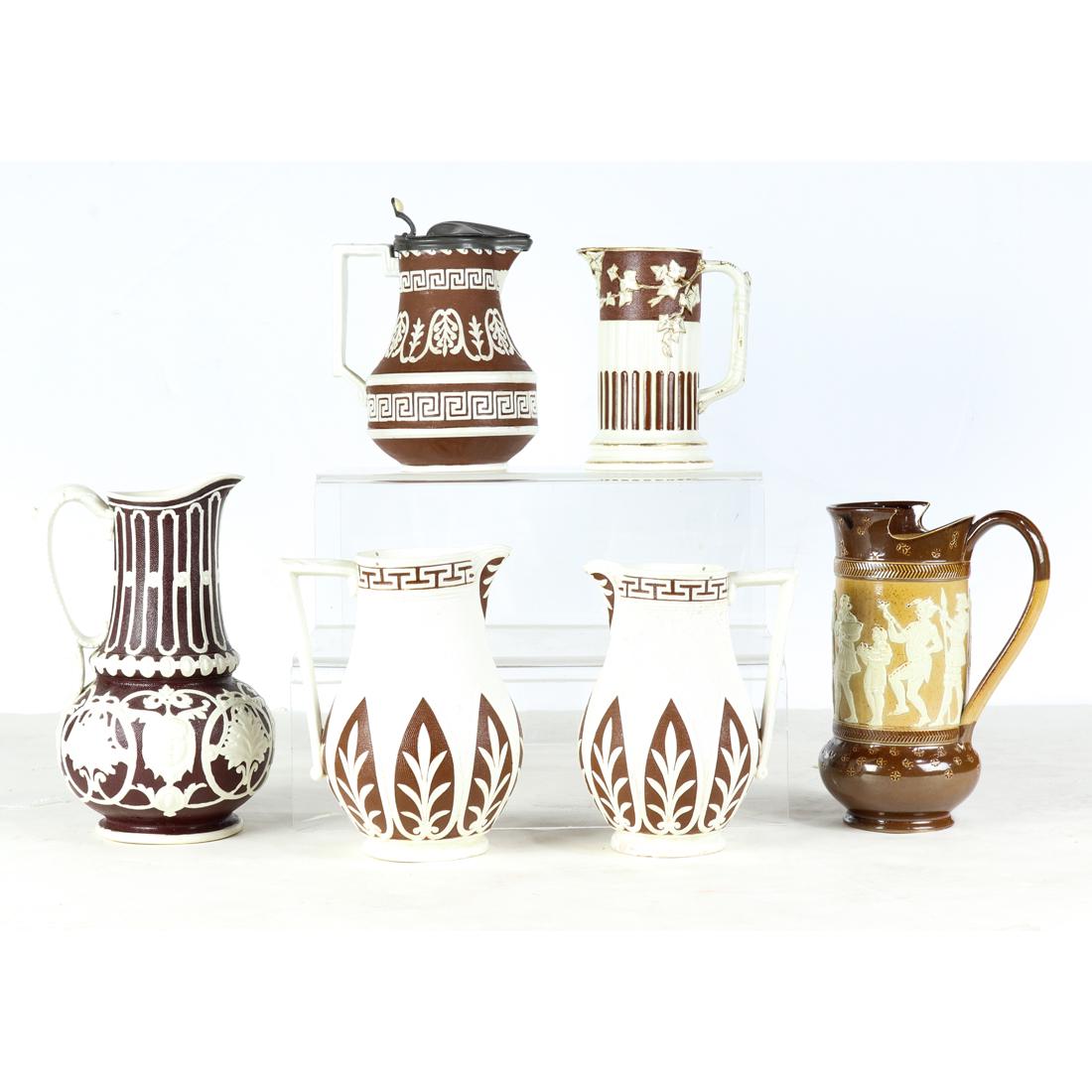 (lot of 6) American or English relief decorated parian: (lot of 6) American or English relief decorated parian or stoneware pitchers, 19th century, consisting of Doulton Lambeth stoneware pitcher, various impressed marks; (2) W.B. Cobridge pitchers; Brownf