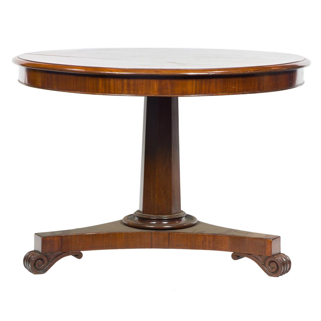 Empire style mahogany center table: Empire style mahogany center table, having a circular top, above a faceted standard, and rising on a tripod base terminating on inswept feet, 29"h x 41"dia.