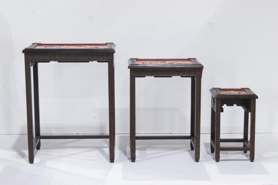 Chinese carved wood nest of three tables: Chinese carved wood nest of three tables, the tops painted in red and decorated with mother of pearl, stone and composit figural decoration 28"h x 20"w x 13"d