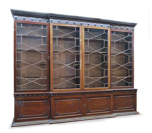 George III breakfront library bookcase: George III carved mahogany breakfront bookcase circa 1800, having an acanthus carved crest above a rose medallion carved cornice surmounting the four mullioned and glazed doors opening to reveal the a