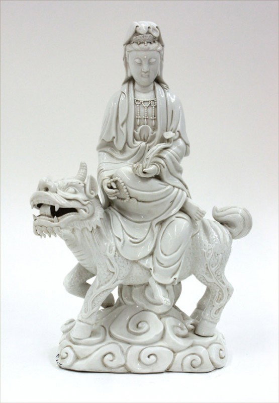 Chinese Dehua/White Ware Buddhist Figure, 20th C: Chinese Dehua (white wear) porcelain figure of a bodhisattva, 20th century, probably Manjusri seated in a pose of royal ease on the back of a mythical qilin, the Buddhist deity in princely raiment and