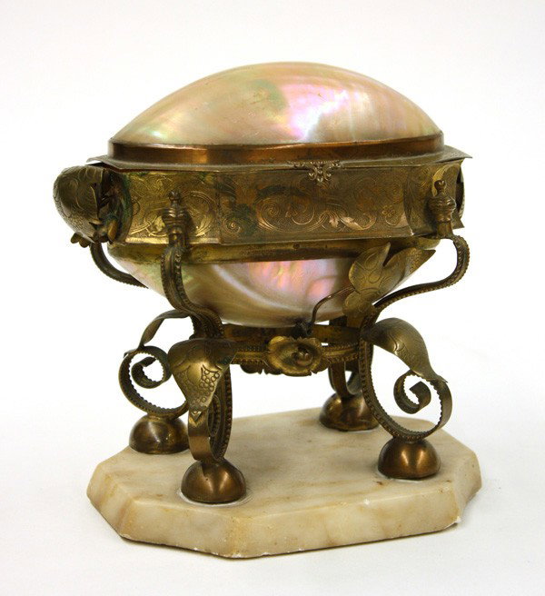 Brass and iridescent mother of pearl casket: Brass and iridescent mother of pearl casket, the mollusk shell having a ovoid form and supported by a brass frame, having an acanthus decoration, and raised on four volute scrolling legs, terminating 