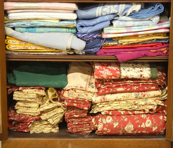 Fine French & Italian table linens: Two shelves of fine table linens, including Damask, Acanthus and Jacquard, some are made in France and Italy, in various colors and patterns, the linens include tablecloths, placements and napkins