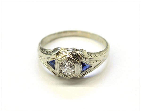 Sapphire diamond ring white gold: Blue sapphire and diamond ring; mounted in 18k white gold, set with (1) round diamond weighing 0.40 ct and (2) triangle shaped blue sapphires. Total ring weight 5.7 grams. Ring size 12