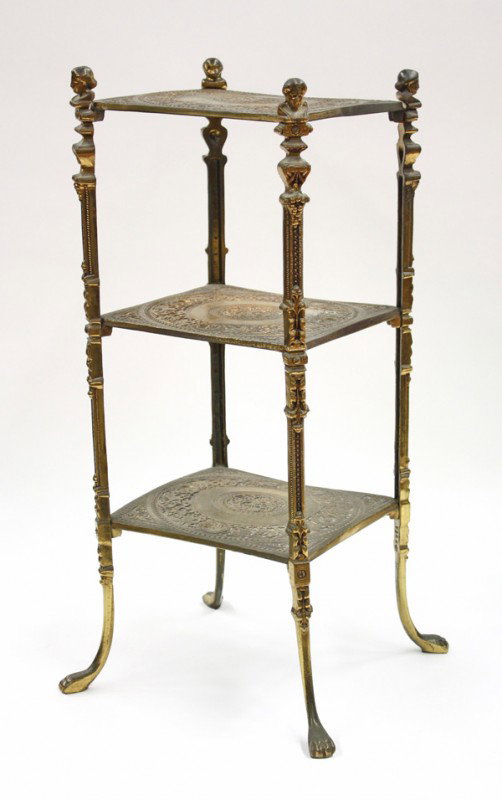 Victorian tiered cake stand: Brass tiered cake stand, having figural capped supports conjoining the three decorated tiers and terminating on paw feet, 29''h x 12''w