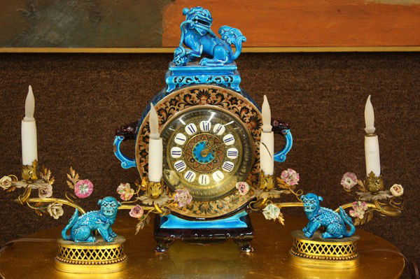American Aesthetic Movement garniture set: (lot of 3) American Aesthetic Movement garniture set, circa 1880, executed in the Asian taste, the polychrome decorated body having a Foo dog finial above the circular dial with raised enamel roman nu