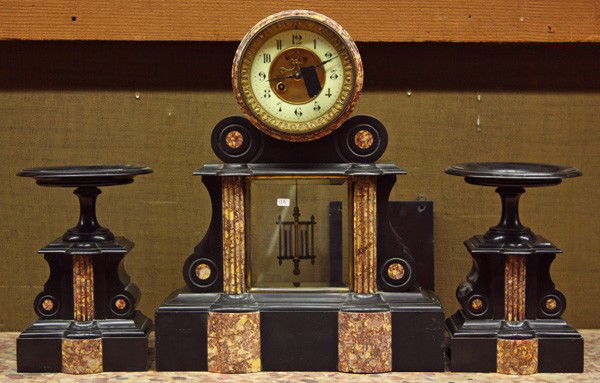 French clock and garniture set: French clock and garniture set circa 1880, the mixed stone set having an A.D Mougin regulator clock with an open escapement, the face with Arabic numerals, flanked with two pedestal form garniture wit