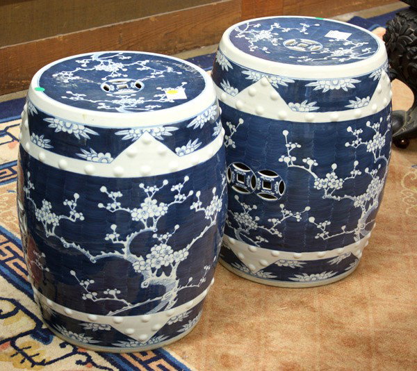Pair Chinese Blue/White Garden Stools: Pair of Chinese blue-and-white porcelain garden seats, each of barrel shape and decorated with branches of flowering prunus reserved on a cobalt blue ground, the top pierced with a cash emblem, furthe